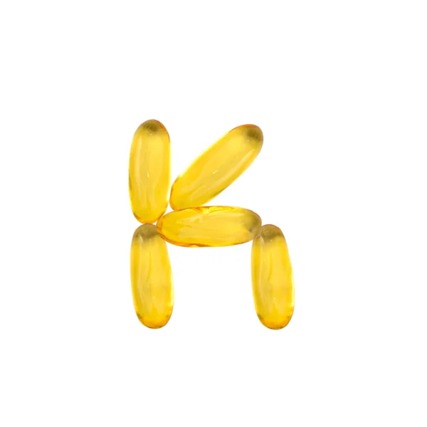 K alfabeto hecho de aceite de pescado píldora —  Fotos de Stock