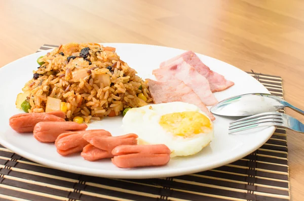 Arroz frito americano con salchicha de cerdo, tocino y huevo frito Imágenes de stock libres de derechos