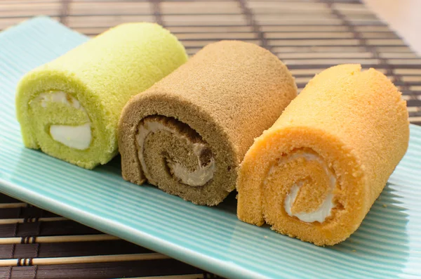 Colorful swiss roll on green dish on bamboo mat Stock Image