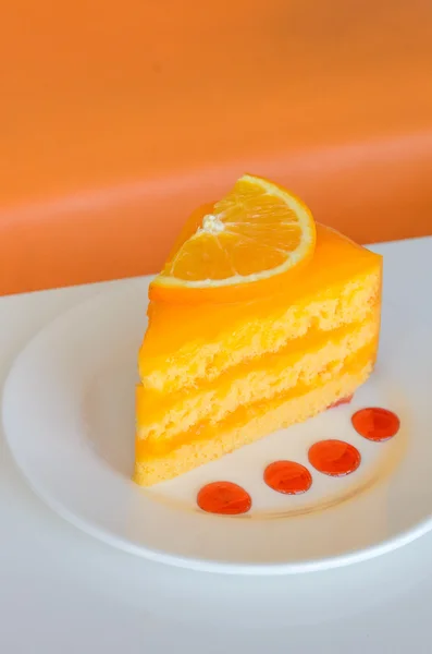 Оранжевый торт на белом столе — стоковое фото