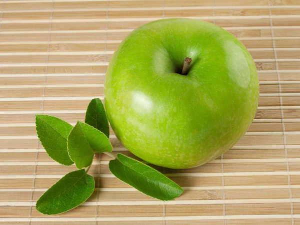 Зелене блискуче яблуко з листям — стокове фото