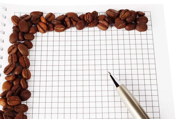 Pen and notepad with coffee beans — Stock Photo, Image