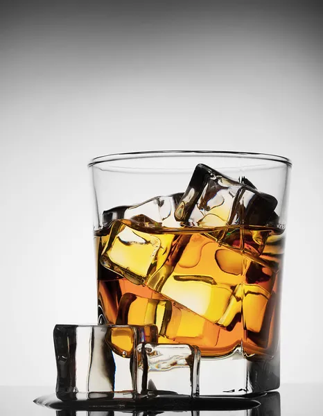 Glass of whiskey with ice melted — Stock Photo, Image