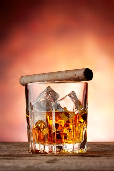 Faceted glass with whiskey and cigar — Stock Photo, Image