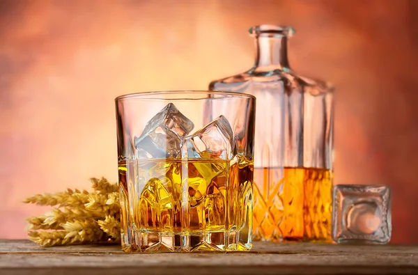 Whiskey with ice and ears of wheat — Stock Photo, Image