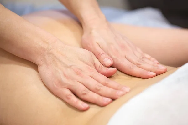 Ręce masażystki na plecach pacjenta — Zdjęcie stockowe
