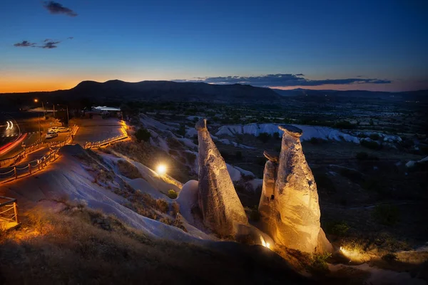 Sprookjesachtige schoorstenen en uitzichtpunt in Cappadocië verlicht door kunstlicht bij zonsondergang — Stockfoto