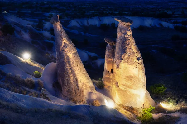 Fairy chimneys of Cappadocia lit by lanterns at sunset — Stock Photo, Image