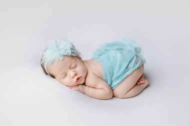  Newborn girl on a white background. Photoshoot for the newborn. A portrait of a beautiful sleeping newborn baby girl