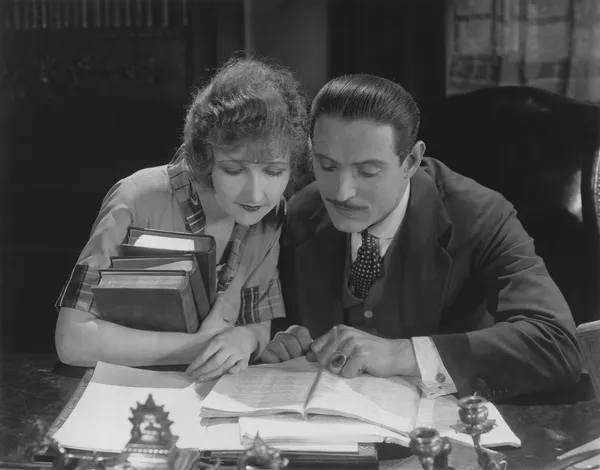 Paar liest Buch am Schreibtisch — Stockfoto