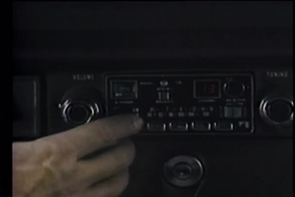 Close-up of hand turning on car radio — Stock Video