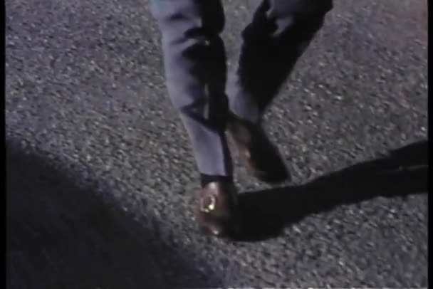 Medium shot of person's feet and legs walking on asphalt — Stock Video