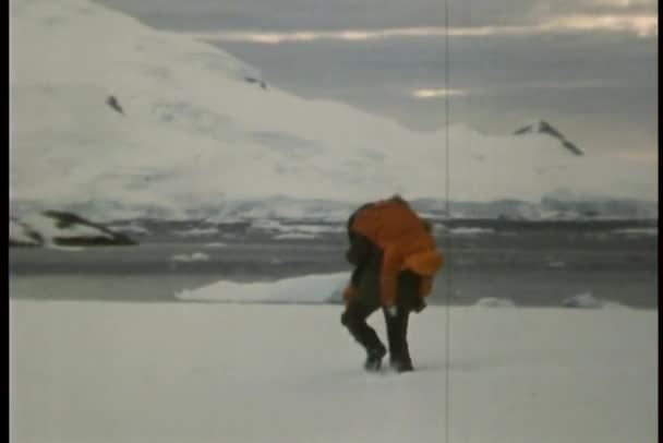 Hombre llevando a la persona sobre el hombro en la nieve — Vídeos de Stock