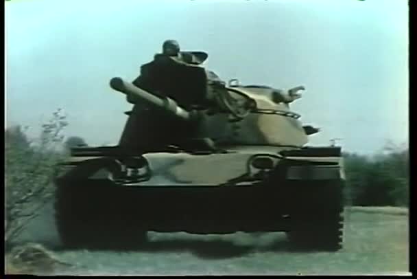 Wide shot of military tanks traveling over grassy area — Stock Video