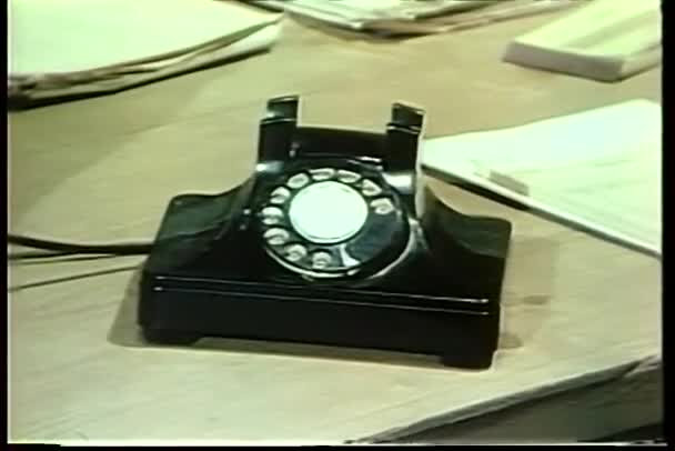 Man med liten anteckningsbok talar rotary telefon — Stockvideo