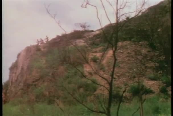 崖の上に立っている槍を保持しているワイド ショットの男性 — ストック動画