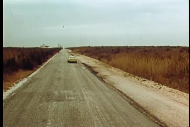 Vista trasera del coche conduciendo por la carretera trasera en el medio de la nada — Vídeo de stock