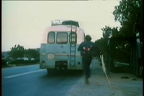 Vista posteriore dell'uomo che salta sul retro dell'autobus in movimento mentre la donna lo insegue — Video Stock