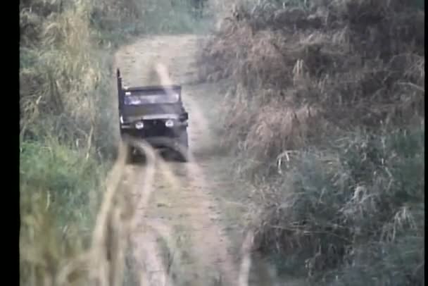 Jeep militaire conduisant sur une petite route de terre — Video