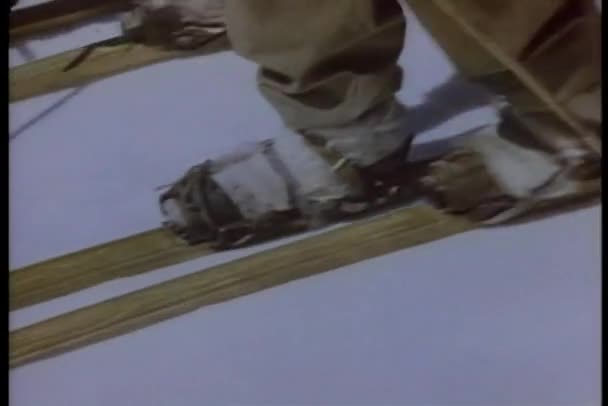 Con esquís y bastones de esquí a través de la nieve — Vídeos de Stock