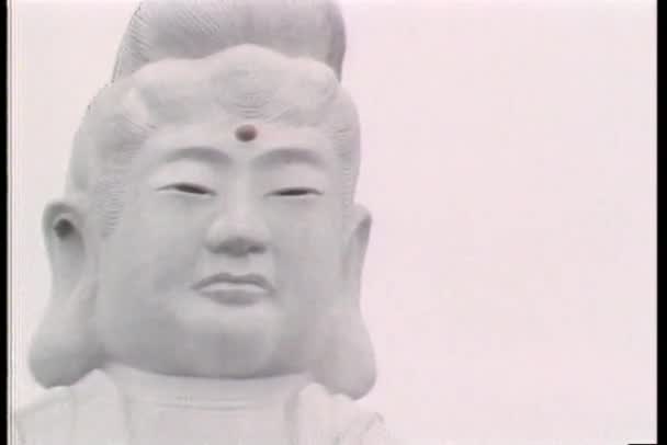 Establishing shot of giant Asian statue and pagoda — Stock Video