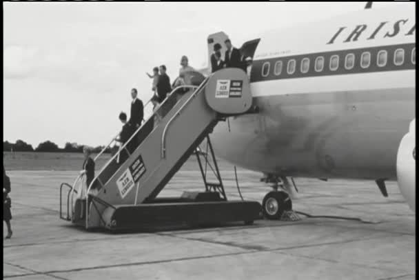 Wide shot passengers disembarking airplane — Stock Video