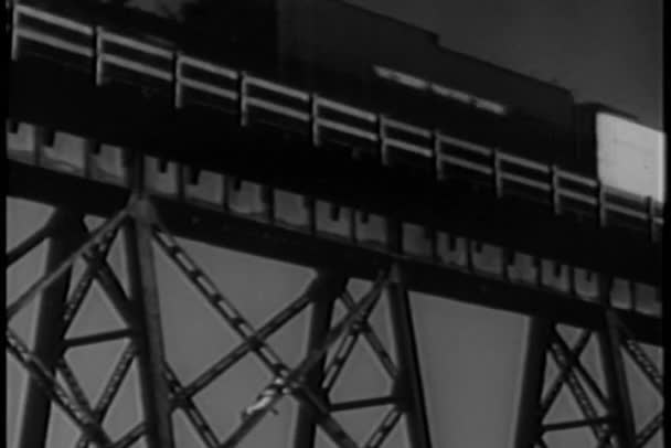 Hombre escalando puente como tren pasa por encima — Vídeos de Stock