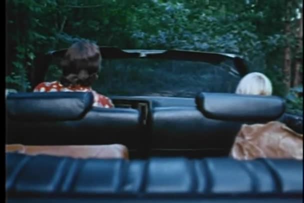 Rear view of man and boy driving through woods in convertible — Stock Video