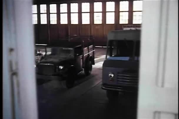 Vista trasera de los hombres apresurándose hacia jeep militar en el garaje — Vídeo de stock