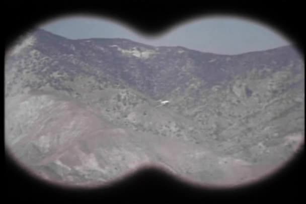 Vista binocular del avión militar que vuela a través de las montañas — Vídeo de stock