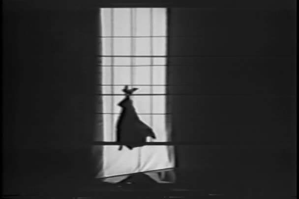 Mann im Fledermauskostüm klettert Seil aus Fenster — Stockvideo