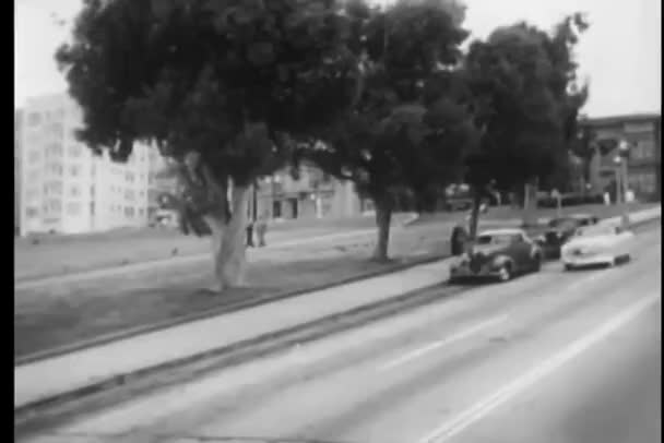 Полицейский на мотоцикле останавливается старинный автомобиль на обочине дороги, Сан-Франциско, Калифорния, США — стоковое видео