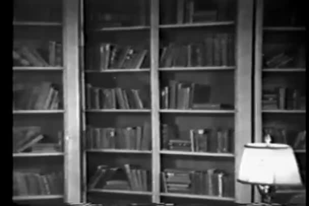 Wide shot van geheime bookshelf openen en sluiten — Stockvideo