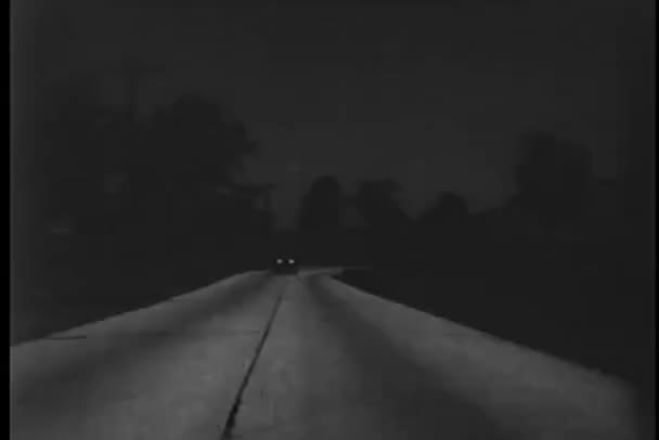 Автомобиль в стиле ретро на проселочной дороге ночью — стоковое видео