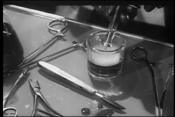 从玻璃的液体灌装注射器戴手套的手的特写 — 图库视频影像