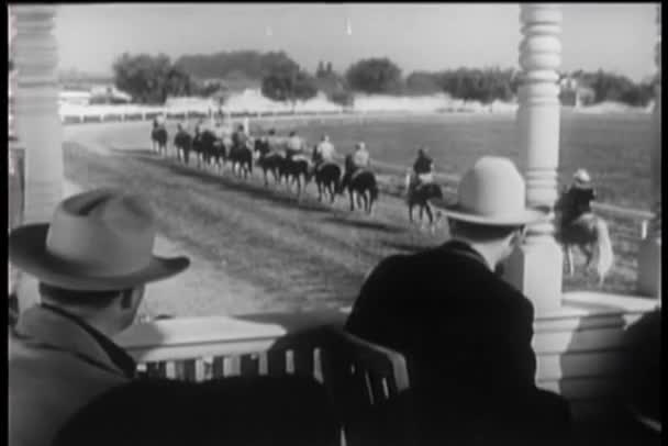 Espectadores en cabina observando el inicio de la carrera de caballos — Vídeo de stock