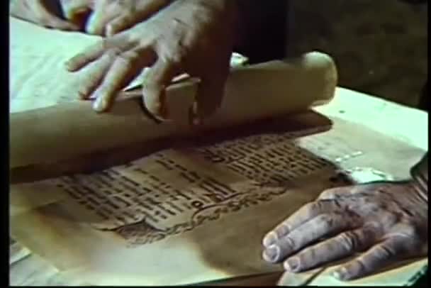 Close-up of hands unrolling scroll — Stock Video