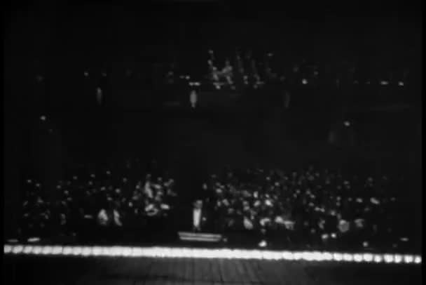 Аудиторія на оркестрових сидіннях аплодує як краплі завіси — стокове відео