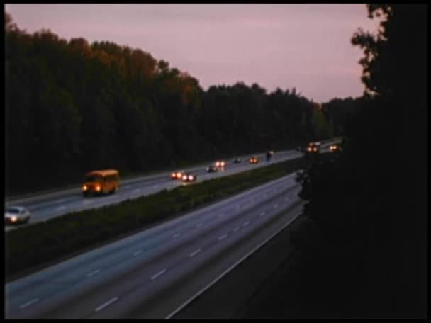 Coches conduciendo por carretera al atardecer — Vídeo de stock