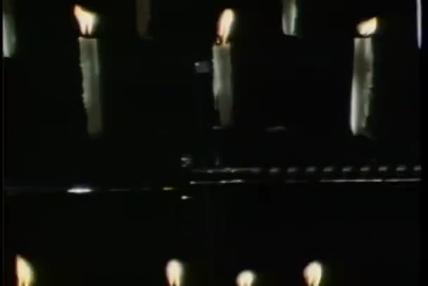 Zoom a filas de velas encendidas — Vídeo de stock