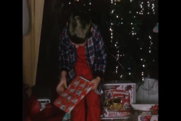 Pequeño niño desenvolviendo regalos de Navidad — Vídeos de Stock