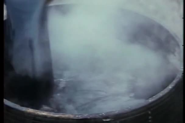 Oil mixed in water boiling in a cauldron — Stock Video