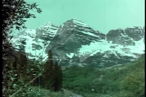 Vista posteriore della ragazza e l'uomo anziano guardando le montagne — Video Stock