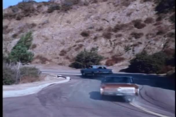 在蜿蜒的山路上高速度的车追 — 图库视频影像