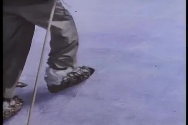 Close-up de pernas movendo-se lentamente no gelo com a ajuda de bastões de esqui — Vídeo de Stock