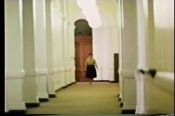 Mulher de tiro longo em uma pressa andando pelo corredor longo — Vídeo de Stock