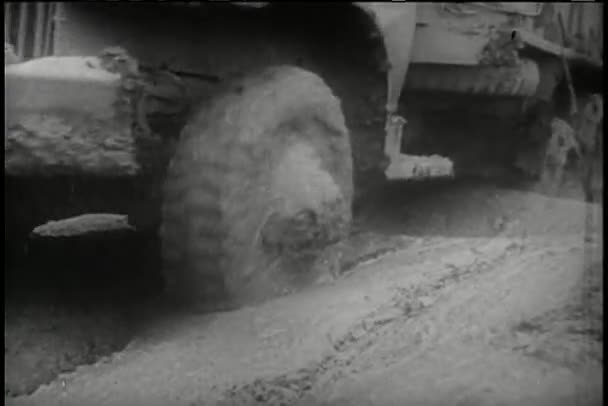 Грузовики с низким углом обзора проезжают грязную дорогу — стоковое видео