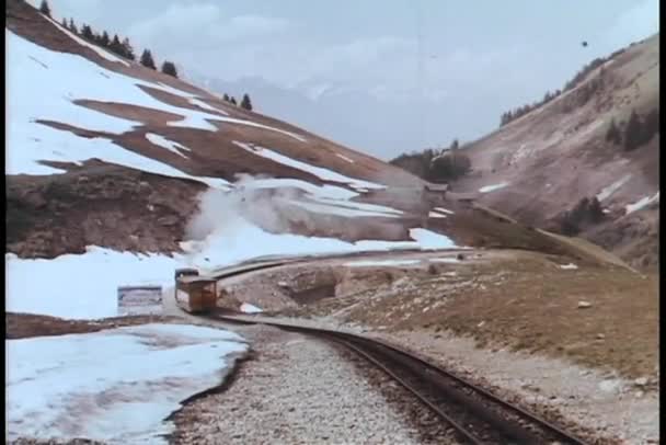 Trein rijden op spoorweg spoor via gebergte — Stockvideo