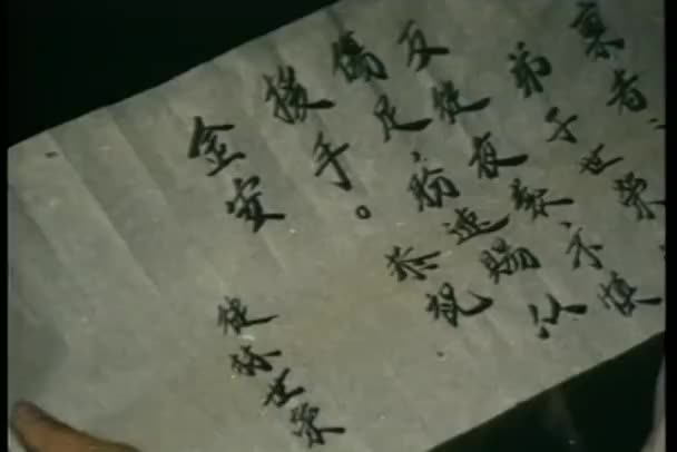 Acercamiento manos arrugado nota escrita en chino — Vídeo de stock