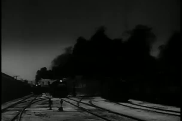Comboio de tiro longo puxando para a estação à noite — Vídeo de Stock